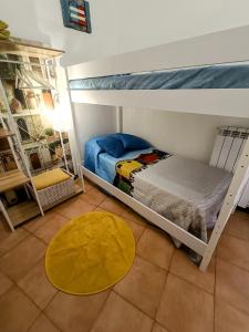 a bedroom with two bunk beds and a yellow rug at Il Balconcino sul carugio in Monterosso al Mare