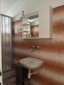 ein Badezimmer mit Waschbecken und Spiegel in der Unterkunft Apartman Marinac in Podstrana