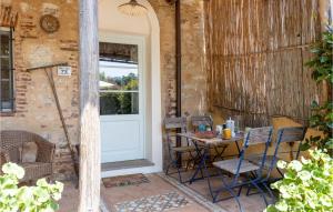 eine Terrasse mit einem Tisch, Stühlen und einer Tür in der Unterkunft Cozy Home In Orbicciano With Wifi in Monsagrati