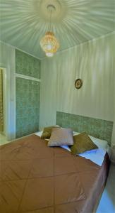 een slaapkamer met een groot bed en een kroonluchter bij Iris' Apartment in Thessaloniki