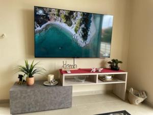 a living room with a flat screen tv on a wall at Cozy apartment Kokkoni beach in Kokóni