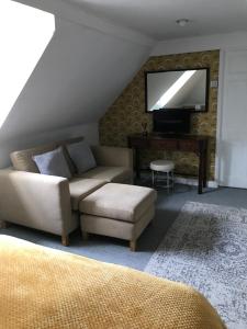 a living room with a couch and a tv at The Lodge at Briar house in Long Melford