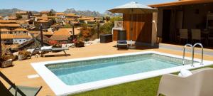 a swimming pool on a deck with a view of a city at Pitões NatureHouse in Pitões das Júnias