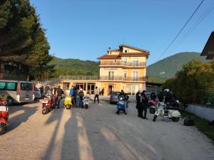 un grupo de personas en motocicletas estacionado frente a un edificio en Hotel Grazia Ristorante, en LʼAquila
