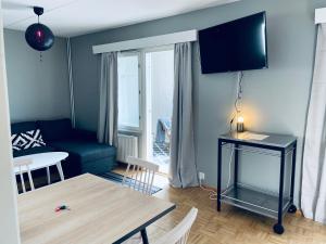 sala de estar con sofá azul y mesa en Tapiola City Apartment, en Espoo