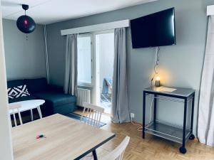 a living room with a blue couch and a table at Tapiola City Apartment in Espoo +2 photos
