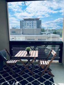 a table and chairs on a balcony with a window at Tapiola City Apartment in Espoo