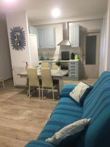 een woonkamer met een blauwe bank en een keuken bij La casita Ossa in Ossa de Montiel