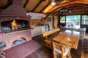 a kitchen and dining room with a brick fireplace at Holiday Home Nina with a heated pool in Brušane