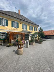 a large yellow building with plants in front of it at Gasthof zur Post in Soding