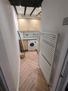 a small kitchen with a washer and dryer at Zeppelin House - Riverside 18th Century Townhouse in Bewdley