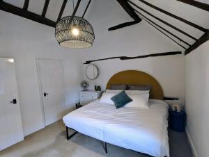 a bedroom with a large white bed and a chandelier at Zeppelin House - Riverside 18th Century Townhouse in Bewdley