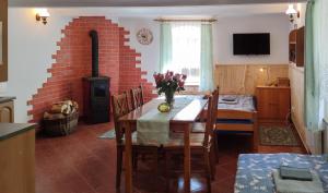 una cucina e una sala da pranzo con tavolo e muro di mattoni di Chalupa Hamr-Kosky a Suchdol nad Lužnicí