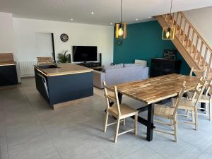 uma cozinha e sala de jantar com uma mesa de madeira e cadeiras em Gîte de saint Calais em Conches-en-Ouche