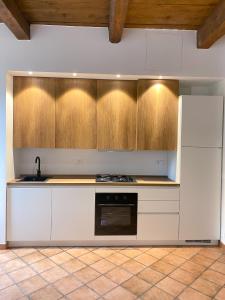 a kitchen with white cabinets and a white refrigerator at Appartamento in centro storico L&L house in Imola