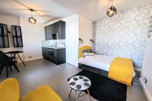 Un dormitorio con una cama amarilla y blanca y una cocina. en Studio 38 - Urban Living in the Heart of Brighton en Brighton & Hove