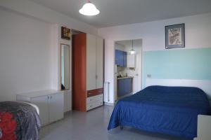 Torre Forteにあるtrilocale "Salina" e monolocale "Panarea" in Portorosaのベッドルーム(青いベッド1台付)、キッチン