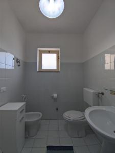 Torre Forteにあるtrilocale "Salina" e monolocale "Panarea" in Portorosaのバスルーム(トイレ、洗面台付)、窓が備わります。