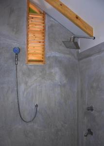 a shower in a bathroom with a window at Trinco Relax Hut in Trincomalee