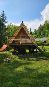 a large wooden house sitting on top of a grass field at U KONC in Stahovica