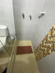 a small bathroom with a shower with a toilet at banana hostel in Bogotá