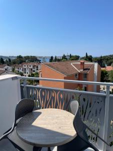 una mesa y sillas en un balcón con vistas en B&B Sea Joy Rovinj, en Rovinj