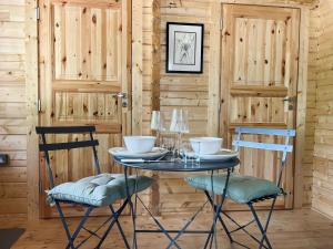 a dining room with a table and two chairs at Log Cabin in Bideford