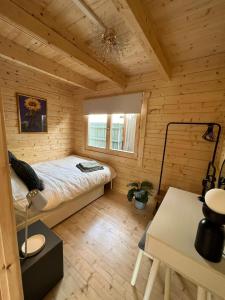 ein Schlafzimmer mit einem Bett in einer Holzhütte in der Unterkunft Log Cabin in Bideford