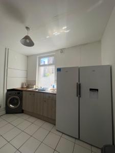 a kitchen with a refrigerator and a washing machine at Large 3 bed - 10 mins to centre in Liverpool