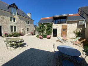 een patio met een tafel en stoelen en een gebouw bij Studio Indre climatisé, La halte de Cuzé, aux abords de la Loire à vélo in Huismes