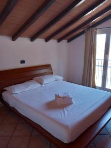 Una cama con cabecero de madera y una bandeja. en Mansarda con terrazza a Diano en Diano Castello