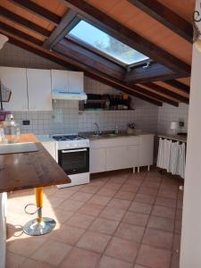 a kitchen with white cabinets and a window at Mansarda con terrazza a Diano in Diano Castello