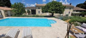 una piscina di fronte a una casa di Au Do'Mayne des Bouilles - Spa & Piscine a Lussac