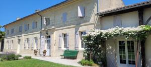 a green bench sitting in front of a building at Au Do'Mayne des Bouilles - Spa & Piscine in Lussac +109 photos