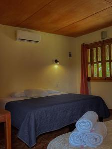 Un dormitorio con una cama azul y una ventana en Ecohabitat, en Xpujil