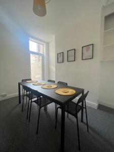a room with a table with chairs and a window at Large 3 bed - 10 mins to centre in Liverpool
