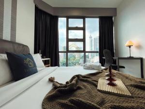 een hotelkamer met een bed en een groot raam bij The Robertson Bukit Bintang Luxe Suites in Kuala Lumpur