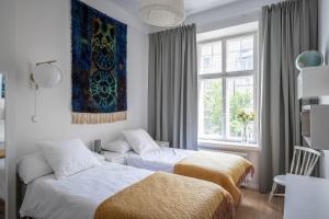 1 dormitorio con 2 camas y ventana en Luxury Design Gem in City Center with Sauna and workspace, en Helsinki