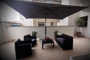 - un salon avec 2 chaises et un parasol dans l'établissement Da Zietta casa dal sapore tipico, à Castellana Grotte