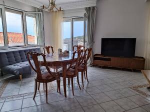 a dining room with a table and chairs and a television at Villa Skala Marion (Michalis) in Skala Marion