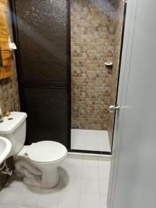 a bathroom with a toilet and a glass shower door at Apartamento STYLE 2 in San Luis