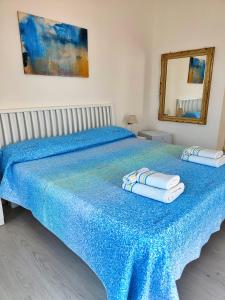 - une chambre avec un lit bleu et des serviettes dans l'établissement Blue Room, à Termoli
