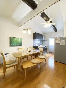 君の家 東寺 في كيوتو: غرفة طعام مع طاولة وكراسي وثلاجة
