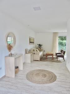 Sala de estar blanca con sofá y mesa en La Casita Amaia en Yerba Buena