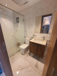 a bathroom with a toilet and a sink and a mirror at Cosy Appartement meublé à Mehdia in Kenitra