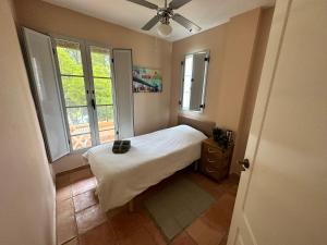 ein kleines Schlafzimmer mit einem Bett und zwei Fenstern in der Unterkunft Casita El Mirador in Cala de Finestrat