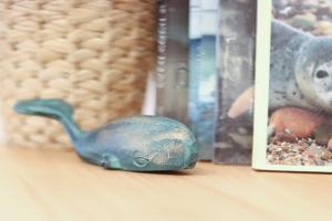una figurita de pájaro azul sentada en un estante junto a los libros en Juister Unterdeck 3ZKB, en Juist