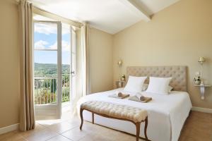 sypialnia z dużym łóżkiem i dużym oknem w obiekcie Golf Resort & Country Club Saint-Tropez w Saint-Tropez