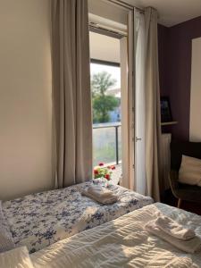 sypialnia z łóżkiem i oknem z ręcznikami w obiekcie Apartamenty Warszawa Centrum Włodarzewska 30 m45 w Warszawie