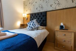 a bedroom with a large bed with a blue blanket at 1 Regent Square, Rye - for a perfect break in Rye